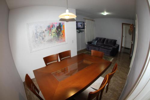 a dining room with a wooden table and chairs at Residencial MBoicy in Foz do Iguaçu