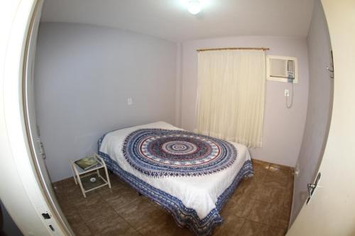 a small room with a bed and a window at Residencial MBoicy in Foz do Iguaçu