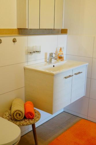 a kitchen with a sink and a stool with towels at Augusta-Refugium in Augsburg