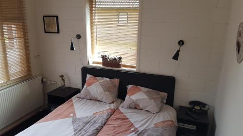 a bedroom with a bed with two pillows on it at vakantiehuis en appartement De Harscamp in Harskamp