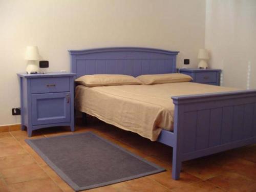 ein blaues Bett mit zwei Nachttischen und zwei blauen Tischen in der Unterkunft Casetta al Lago in Carmine