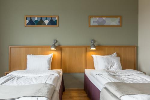 two beds sitting next to each other in a room at Bohusgården Hotell & Konferens in Uddevalla