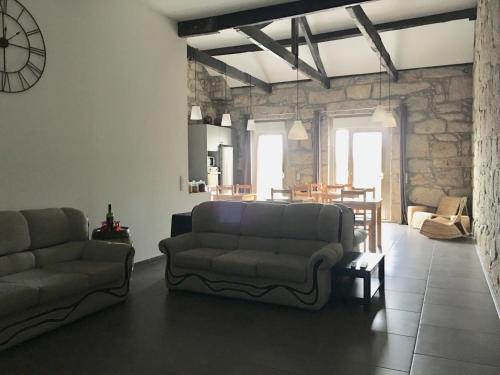 a living room with two couches and a stone wall at Campanhã Boutique Station in Porto