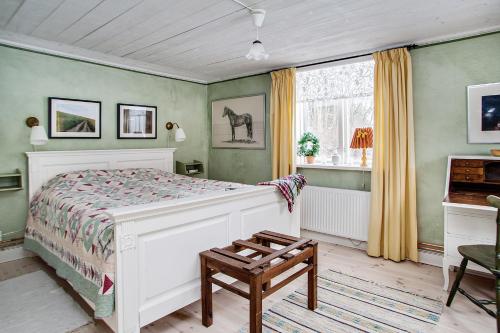 a bedroom with a white bed and a window at Ängsö Fishermans Cottage in Västerås