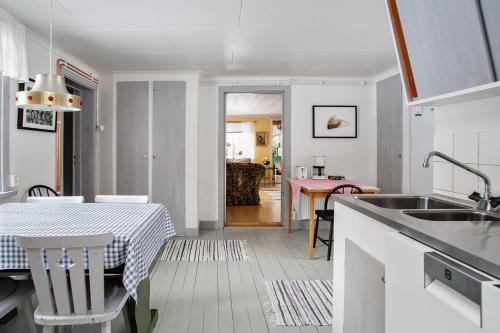 a kitchen and dining room with a table and a kitchen and a dining room at Ängsö Fishermans Cottage in Västerås