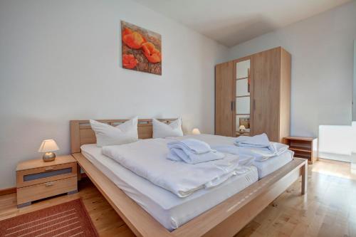 a bedroom with a large bed with white sheets at Haus Meerblick - 12 in Ahlbeck