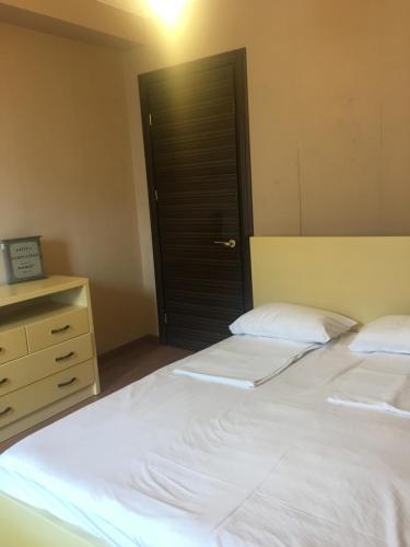 1 dormitorio con 2 camas, vestidor y puerta en Apartment Sea Avenue en Batumi