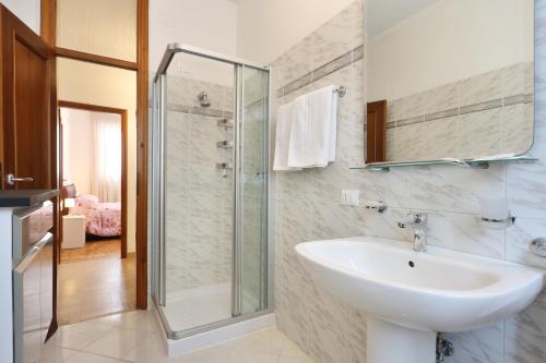 a bathroom with a sink and a glass shower at Lupori House in Viareggio