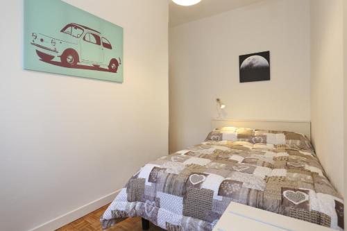een slaapkamer met een bed en een foto van een busje aan de muur bij Lupori House in Viareggio