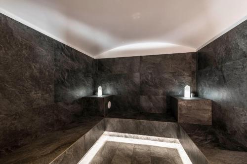 een badkamer met zwarte muren en een bad bij Hotel Waldsee in Fiè