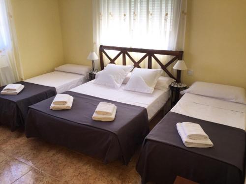 a bedroom with two beds with towels on them at Caprirural in Los Ángeles de San Rafael