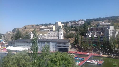 a group of buildings on a hill next to a river at Caprirural in Los Ángeles de San Rafael