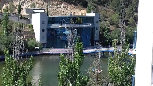 a building on a bridge over a body of water at Caprirural in Los Ángeles de San Rafael