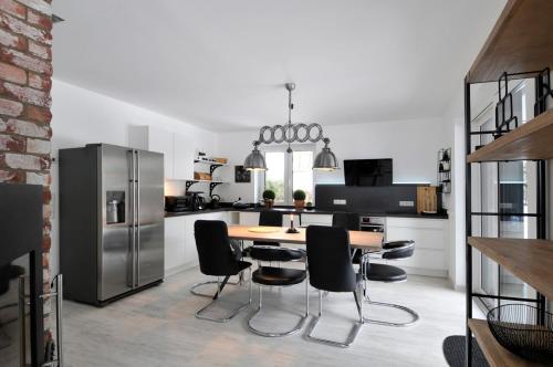een keuken met een tafel en stoelen en een koelkast bij Villa Kiesel in Zempin