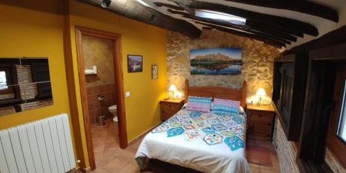 a bedroom with a bed and a bathroom with yellow walls at Hotel La Casa Chacinera in Candelario