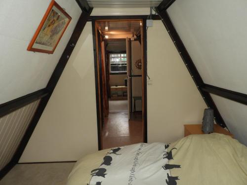 デュルビュイにあるArdennen Vakantie Chaletのベッドと廊下が備わる屋根裏部屋です。