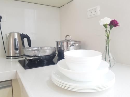 a kitchen counter with plates and a vase with flowers at אבני החושן- Avnei Hoshen in Nahariyya