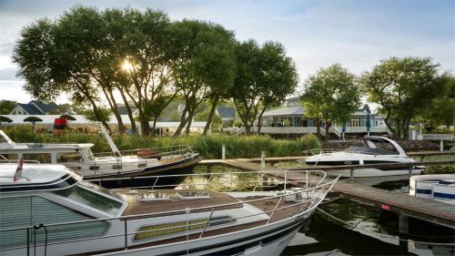 a group of boats docked at a dock at Sunday Schwielowsee Resort - Hotel in Werder