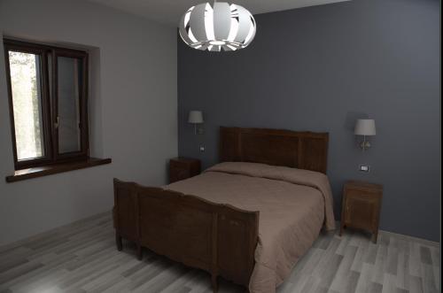 a bedroom with a bed and a chandelier at Agriturismo Il Parco in Nusco