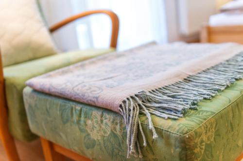 a green couch with a blanket on top of it at Landhaus Fux in Silandro