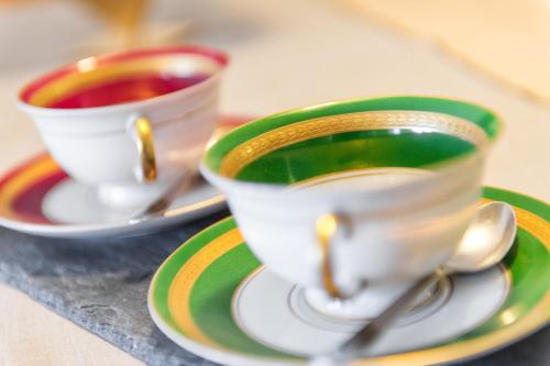two cups of coffee sitting on plates on a table at Landhaus Fux in Silandro