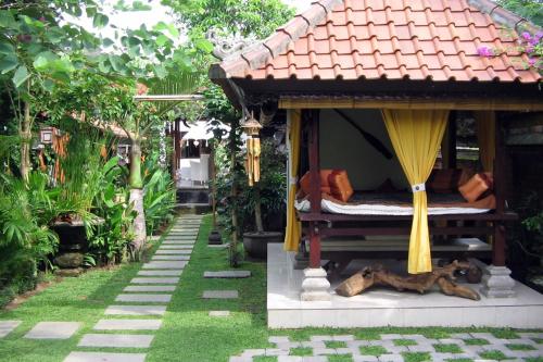 a bed in a small house in a garden at Puri Ayu in Canggu