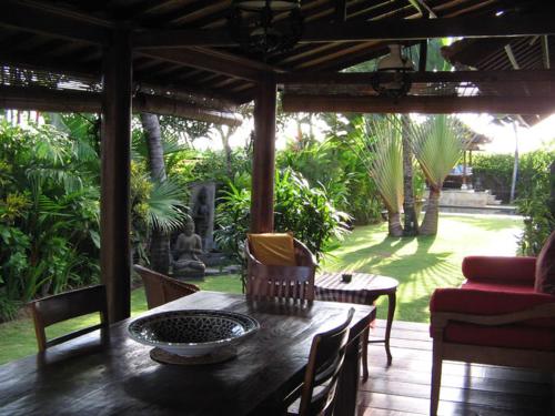 a wooden table and chairs on a patio at Puri Ayu in Canggu