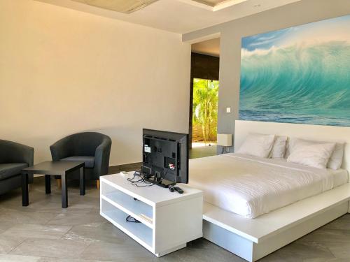 a bedroom with a bed and a tv on a table at Grand Amber Villa in Diani Beach