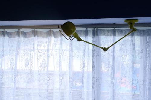 a lamp hanging from a window with white curtains at Hangzhou JiuYueJi Bed&Breakfast in Hangzhou