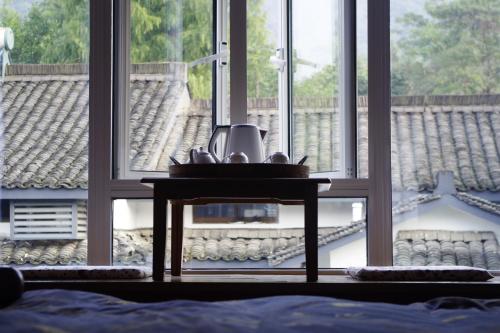 a table in front of a window in a room at Hangzhou JiuYueJi Bed&Breakfast in Hangzhou