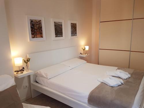 カットーリカにあるAppartamento Darsena con Box Autoのベッドルーム1室(白いベッド1台、ランプ2つ付)