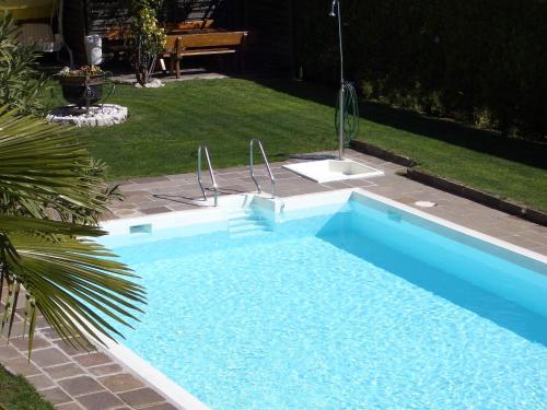 a blue swimming pool with a sink in a yard at Hotel Winzerhof in Termeno