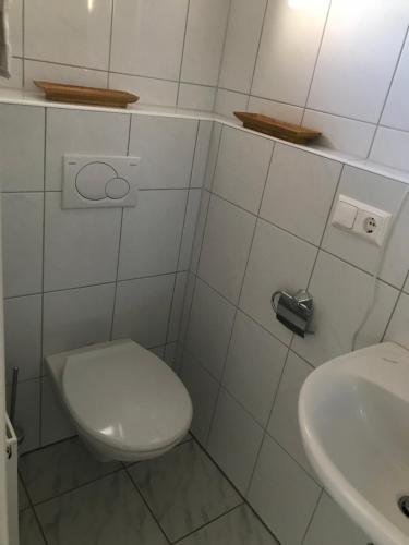 a white bathroom with a toilet and a sink at Gästezimmer am Oos Bach in Baden-Baden