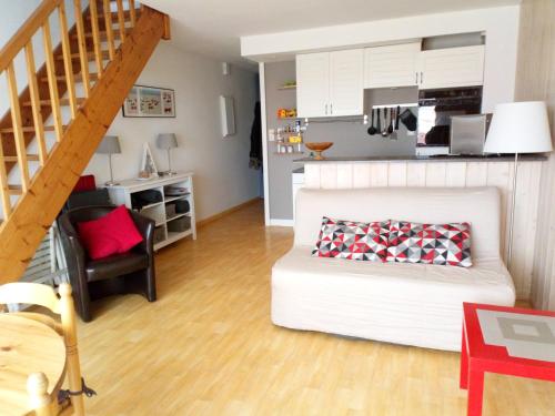 un salon avec un canapé blanc et une cuisine dans l'établissement Appartement vue mer Sion-sur-l'Océan, à Saint-Hilaire-de-Riez