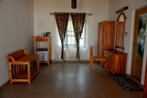 a living room with wooden furniture and a window at Marari Green Villas in Mararikulam