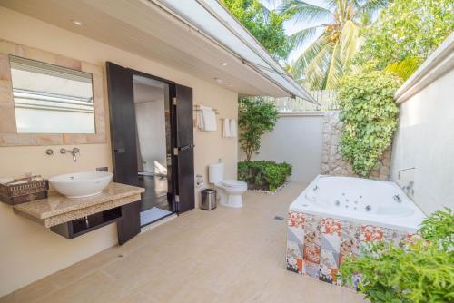 Un baño con bañera, lavabo e inodoro. en The Sunset Beach Resort & Spa, Taling Ngam, Ko Samui, en Taling Ngam