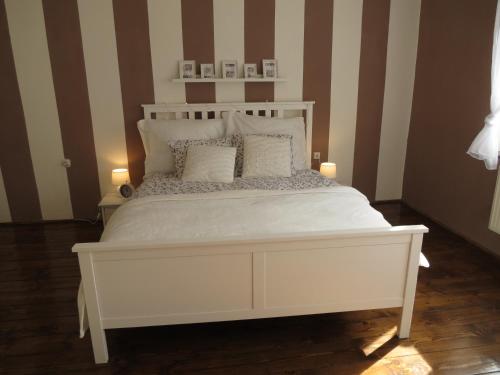 a white bed in a room with striped walls at Ubytování Stará in Ústí nad Labem