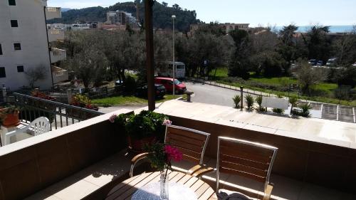 a balcony with two chairs and a table with flowers at Guest house Villa Castio in Petrovac na Moru