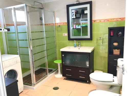 ein Bad mit einer Dusche, einem WC und einem Waschbecken in der Unterkunft Apartamento Holiday on the Beach in Torremolinos