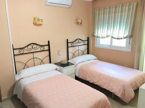 1 Schlafzimmer mit 2 Betten und einem Fenster in der Unterkunft Apartamento Holiday on the Beach in Torremolinos