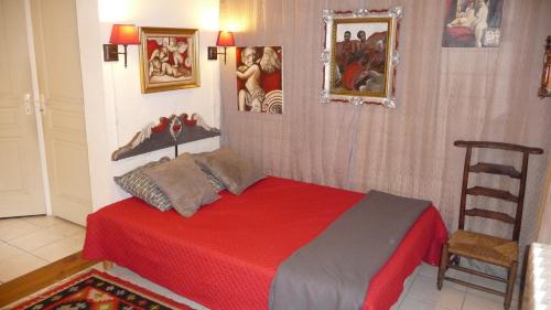 サルラ・ラ・カネダにあるAppartement Aux Armoiries de Sarlatのベッドルーム(赤いベッド1台、椅子付)
