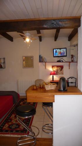 - un salon avec un bureau et un lit dans l'établissement Appartement Aux Armoiries de Sarlat, à Sarlat-la-Canéda