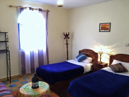 a bedroom with two beds and a window at Camping & Hôtel Le Calme in Essaouira