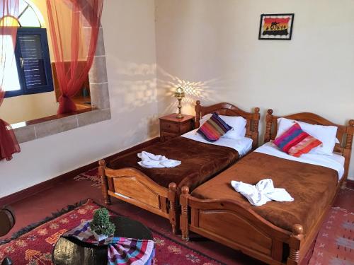 a bedroom with two twin beds with towels on them at Camping & Hôtel Le Calme in Essaouira