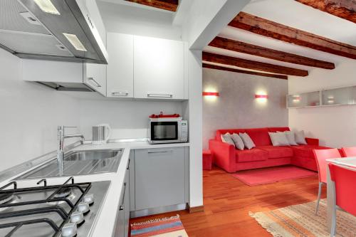 cocina y sala de estar con sofá rojo en Apartment Biennale, en Venecia