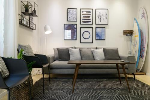 a living room with a couch and a table and surfboards at Beach Apartments TLV - Exclusive in Tel Aviv