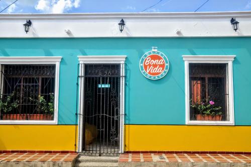 un edificio azul y amarillo con puerta en Bona Vida Hostel, en Ríohacha