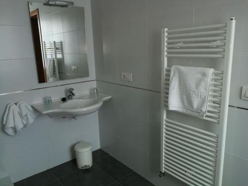 a white bathroom with a sink and a mirror at Pension Restaurante La Bombilla in A Estrada