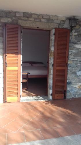 a bedroom with a bed and two open doors at Casa Matilde in Vercana