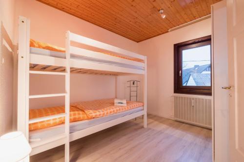 1 dormitorio con 2 literas y ventana en Haus Innerdorf gemütliches Ferienhaus im Taunus, en Pohl